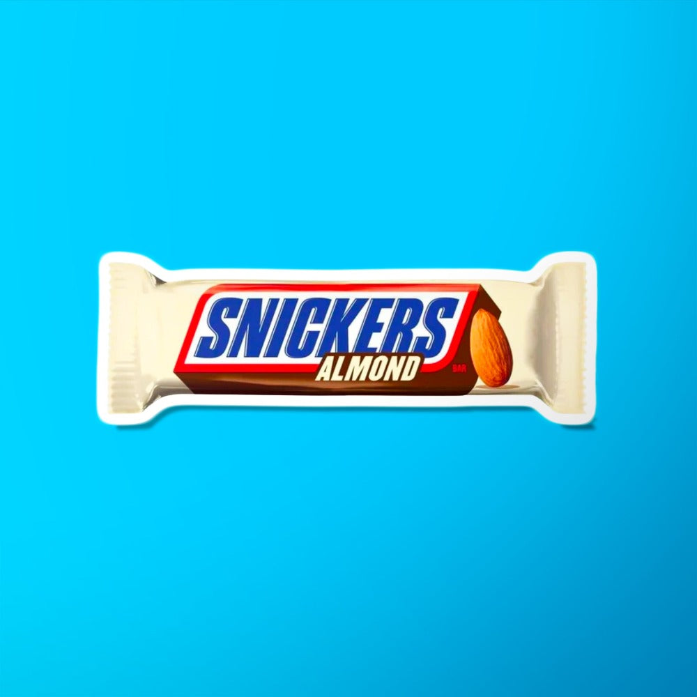 Un emballage beige sur fond bleu avec au centre écrit « Snickers » en bleu et sur le côté droit il y a une amande